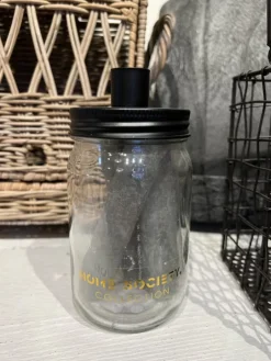 Glazen pot met drie grijze kaarsen